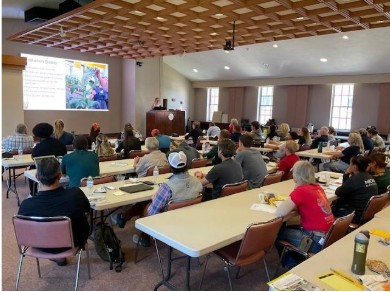 A group of people sitting at tables for a full day Biological Control Conference.